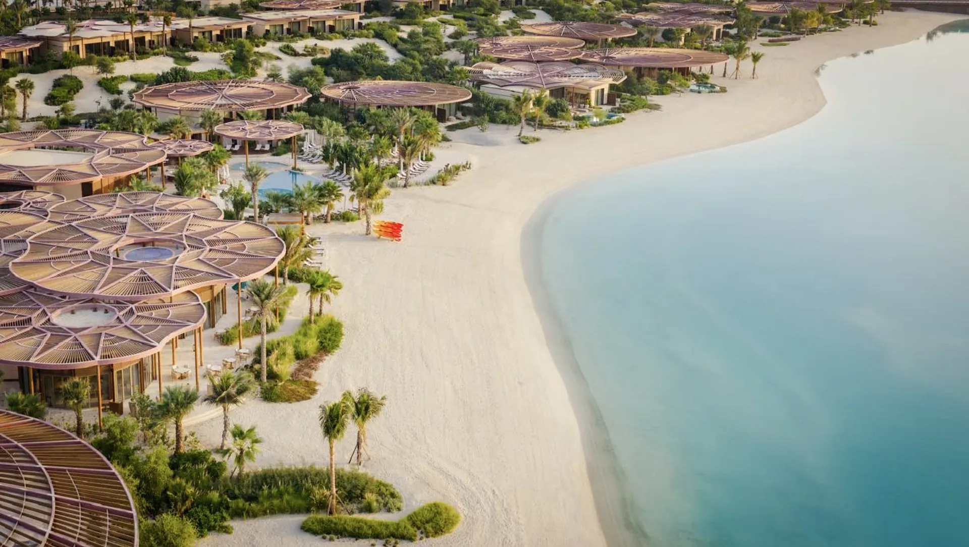 Raffles The Red Sea von oben: Pavillons mit geschwungenen Dächern an einem weißen Strand und einer türkisfarbenen Lagune auf Shura Island