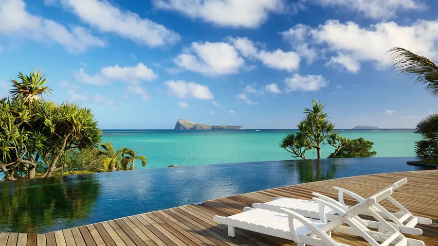 Infinity-Pool mit Sonnenliegen über der Lagune von Mauritius