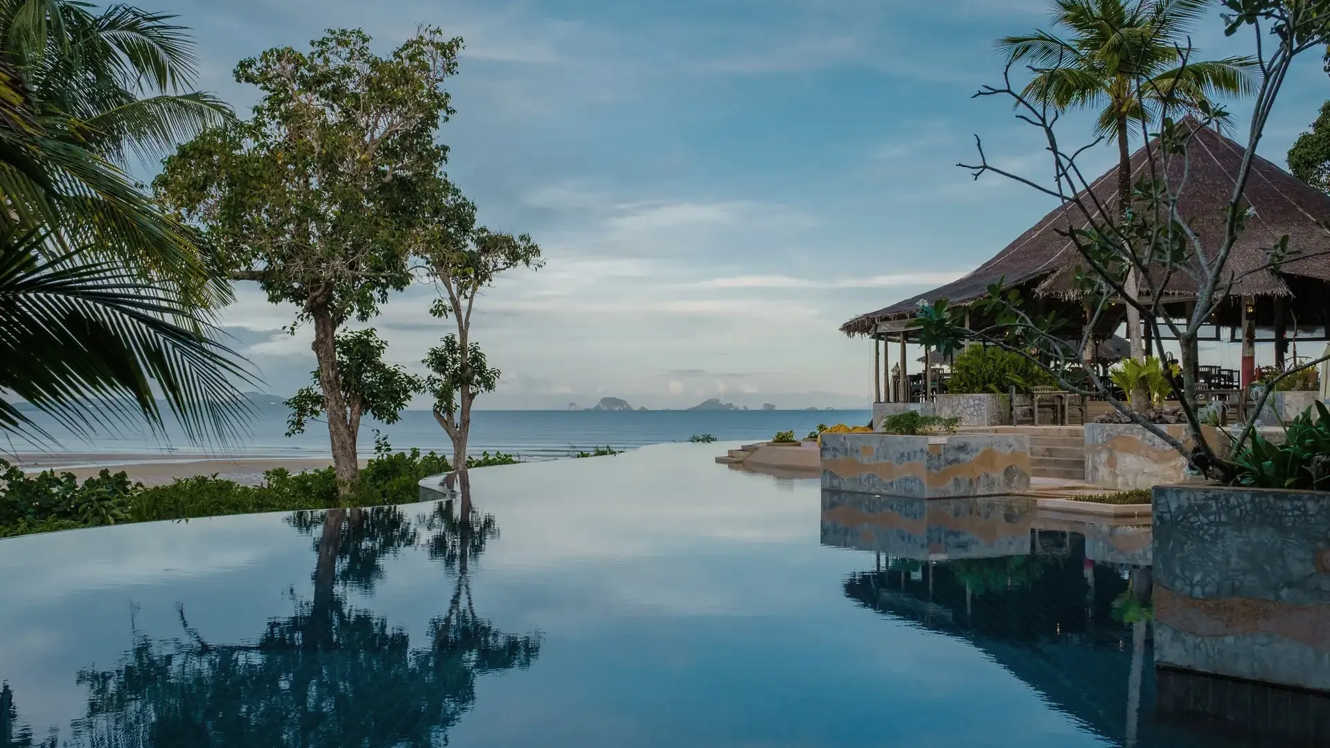 Infinity-Pool, in dem sich Bäume und ein Pavillon spiegeln, über der Andamanensee