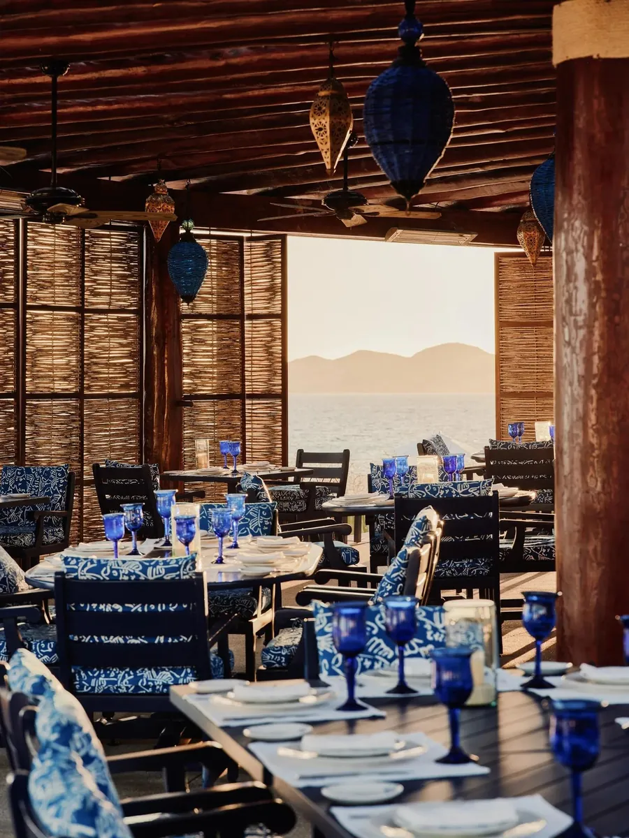 Sea Grill im Rosewood Las Ventanas al Paraíso: Tische mit blauen Gläsern unter einem Palmendach mit Blick auf das Meer