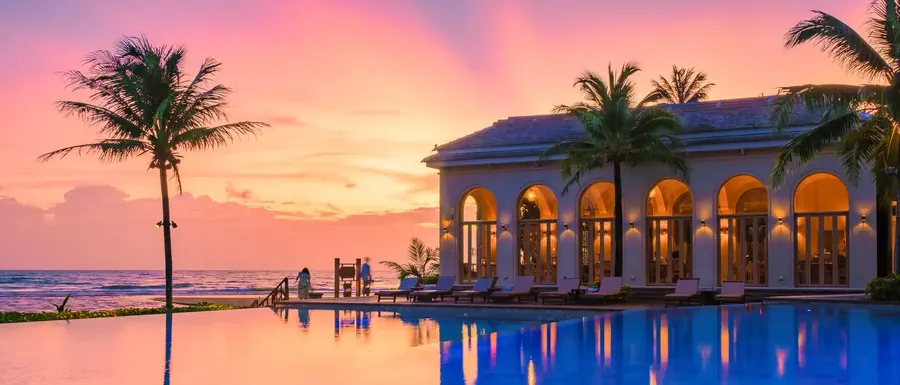 Resortpool und Pavillon mit Arkaden unter rosa Abendhimmel